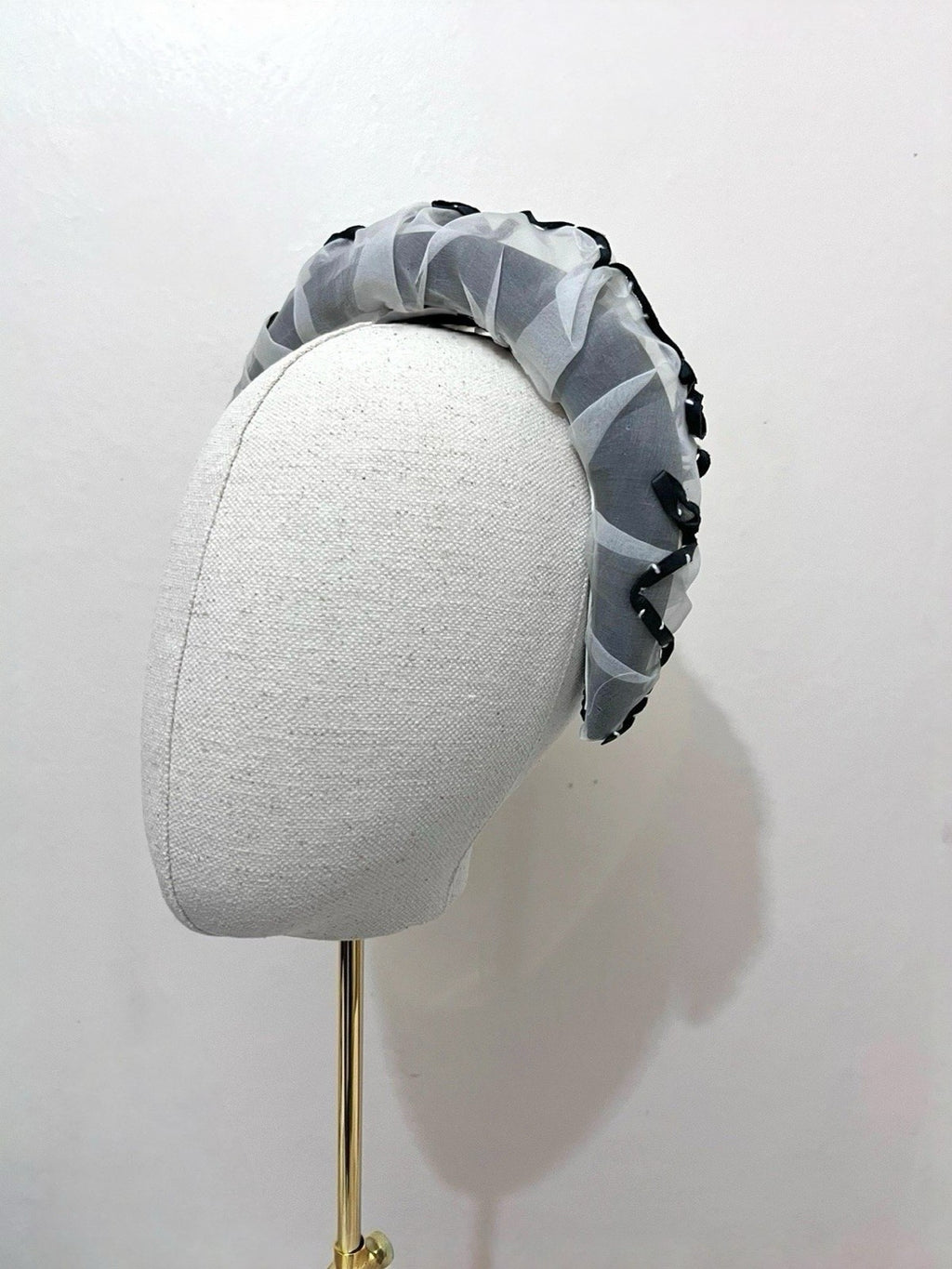 Gray headband with black pattern on a mannequin head against a white background