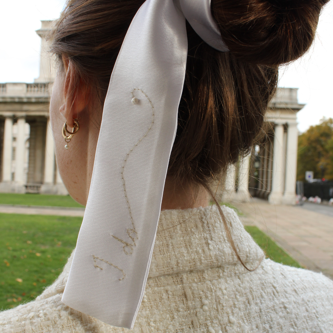 Person wearing a bridal hairband with gold embroidery in an outdoor setting