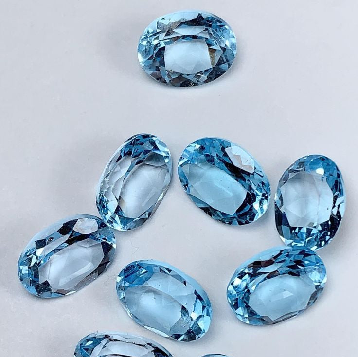 Set of blue topaz gemstones on a light gray background