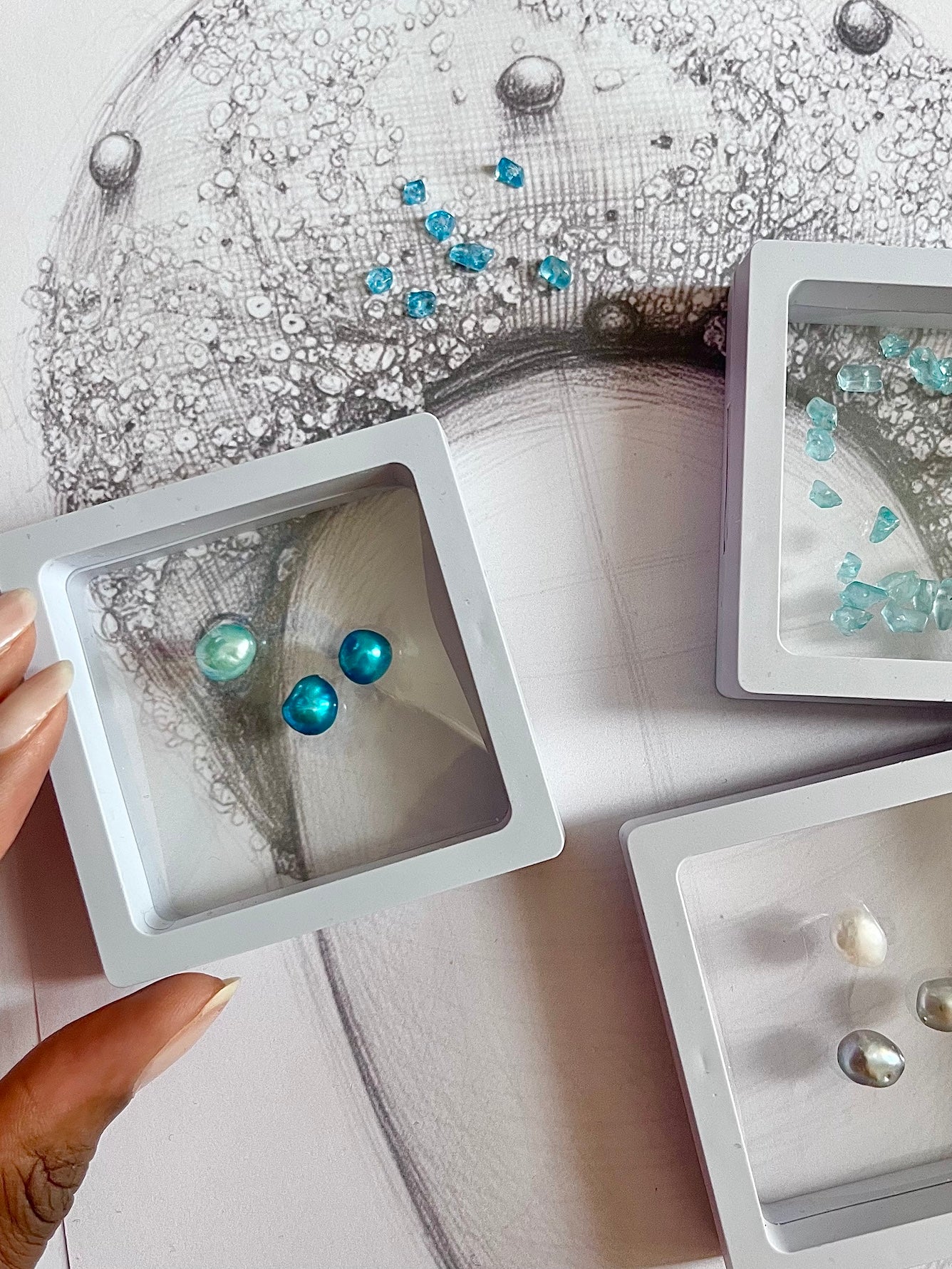 Close-up of gemstones  in clear display cases with a headband drawing