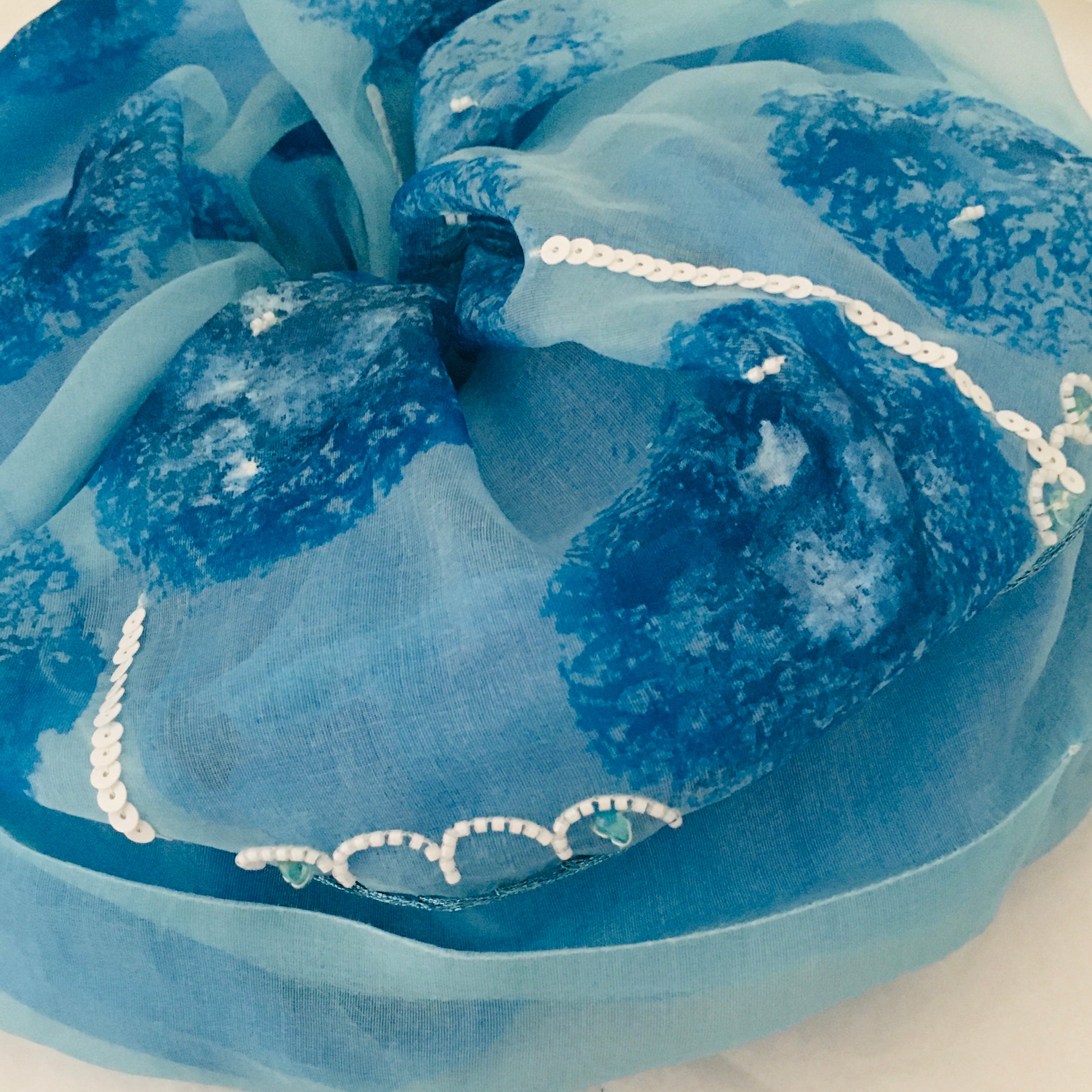Blue fabric with white embroidery on a large scrunchy