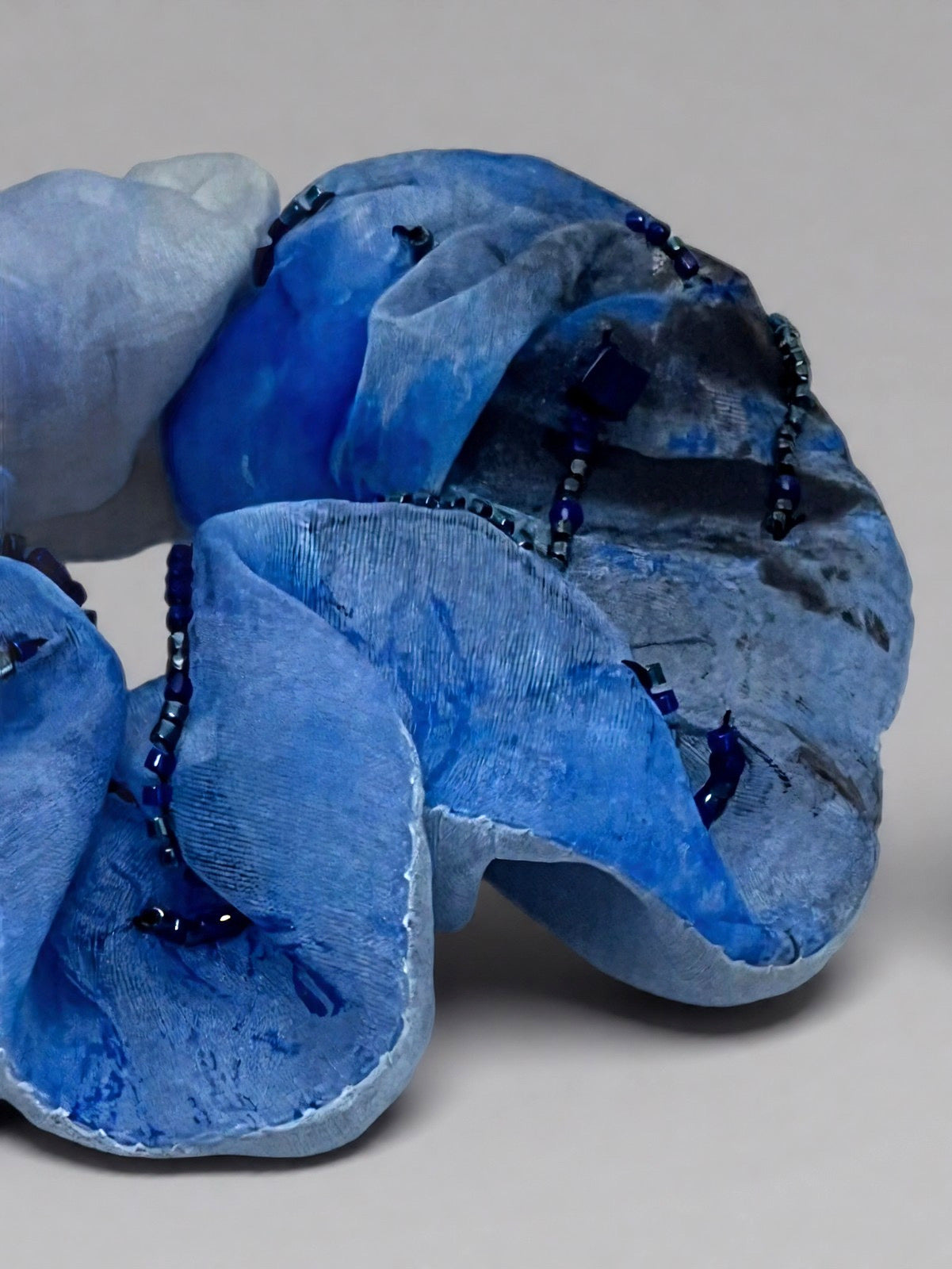 Blue scrunchie with beads on a gray background