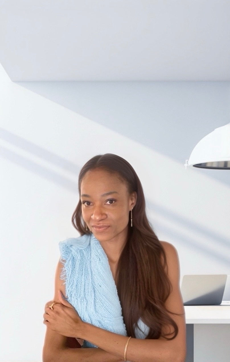 The Zapota hair designer wearing a light blue dress against a white background